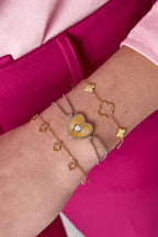 Armband met klavertjes - gedragen om de arm van een model in combinatie met meer armbanden