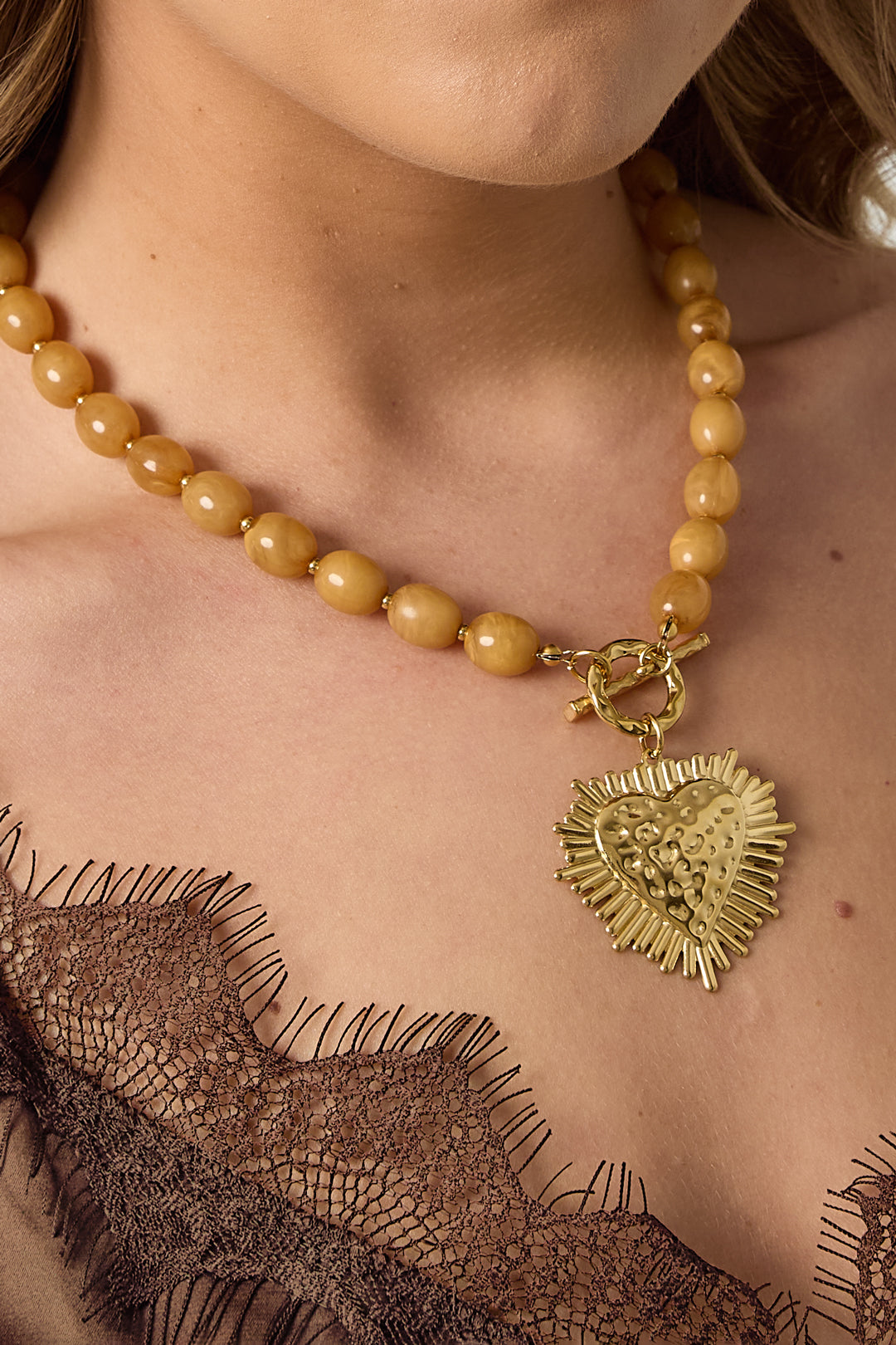 Kralenketting met frontsluitingcharm - kaki - gedragen om de hals van een model