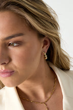 Oorbellen met afwisselende steentjes - goud - gedragen in het oor van een model zijaanzicht