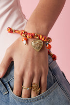 Armbanden met touwbedeltjes in de vorm van een hartje, gedragen om de arm van een model