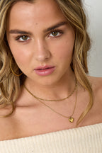 Gelaagde ketting met hartbedeltje - goud - gedragen om de hals van een model