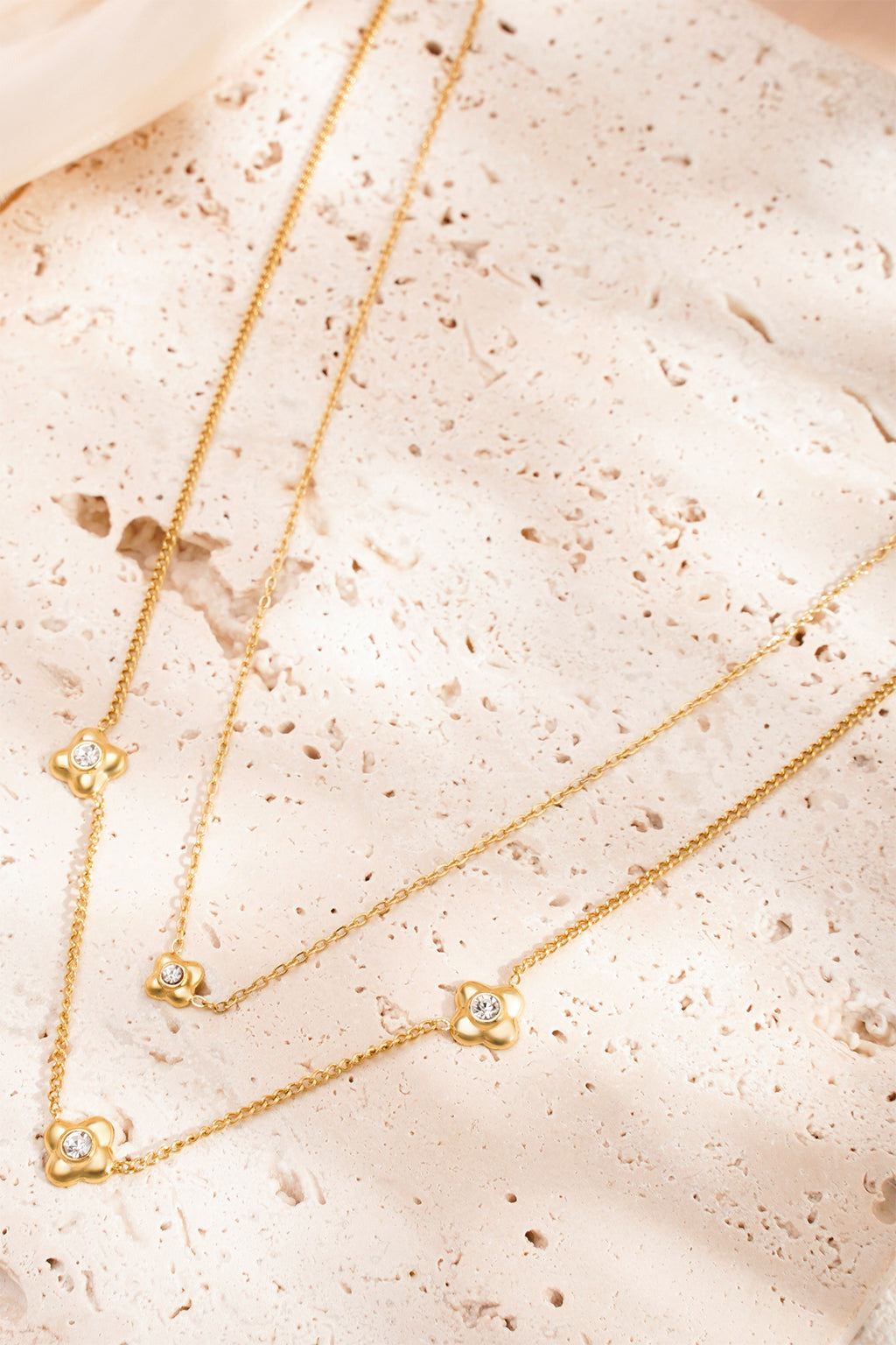 flowery ketting - goud - neergelegd op een stenen oppervlak