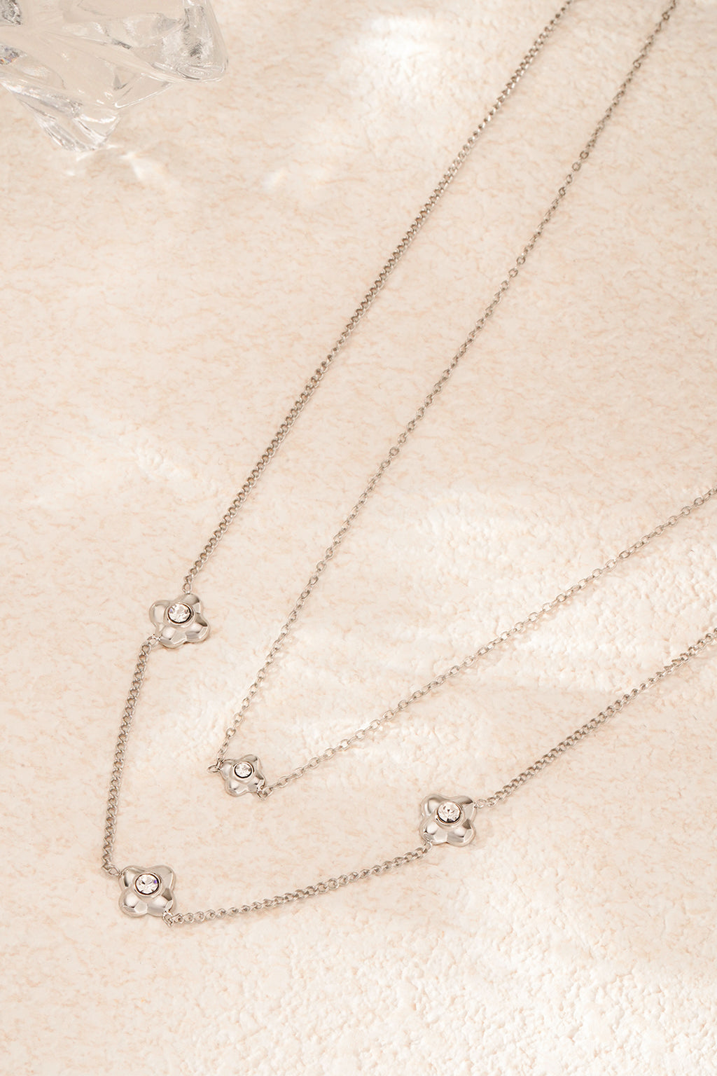 flowery ketting - zilver - neergelegd op een stenen oppervlak