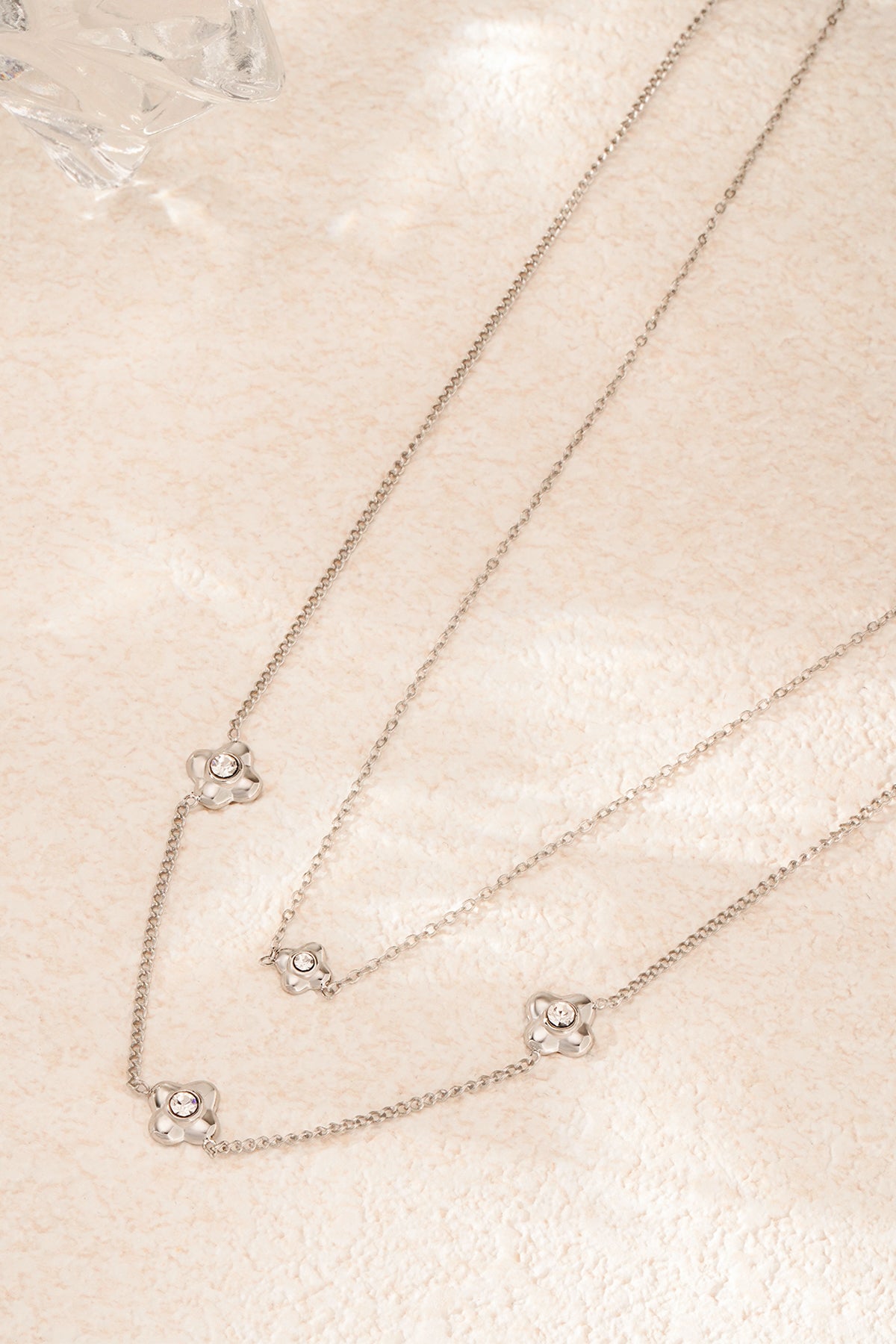 flowery ketting - zilver - neergelegd op een stenen oppervlak