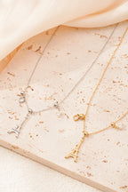 Eiffeltoren ketting - goud en zilver - neergelegd op een decoratieve stenen plaat