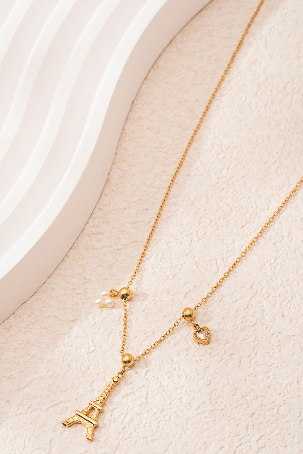 Eiffeltoren ketting - goud - neergelegd op een stenen plaat