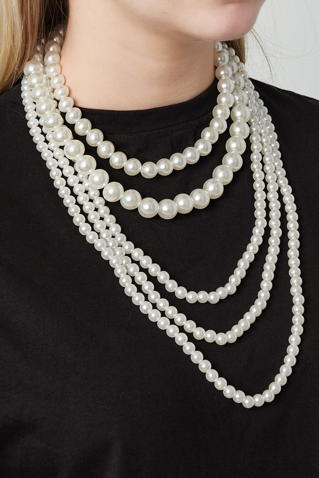 Meerlaagse parel kettingen - gedragen om de hals van een model