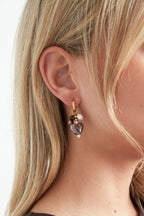 Oorbellen met kraal en hart charms - bruin - gedragen in het oor van een model