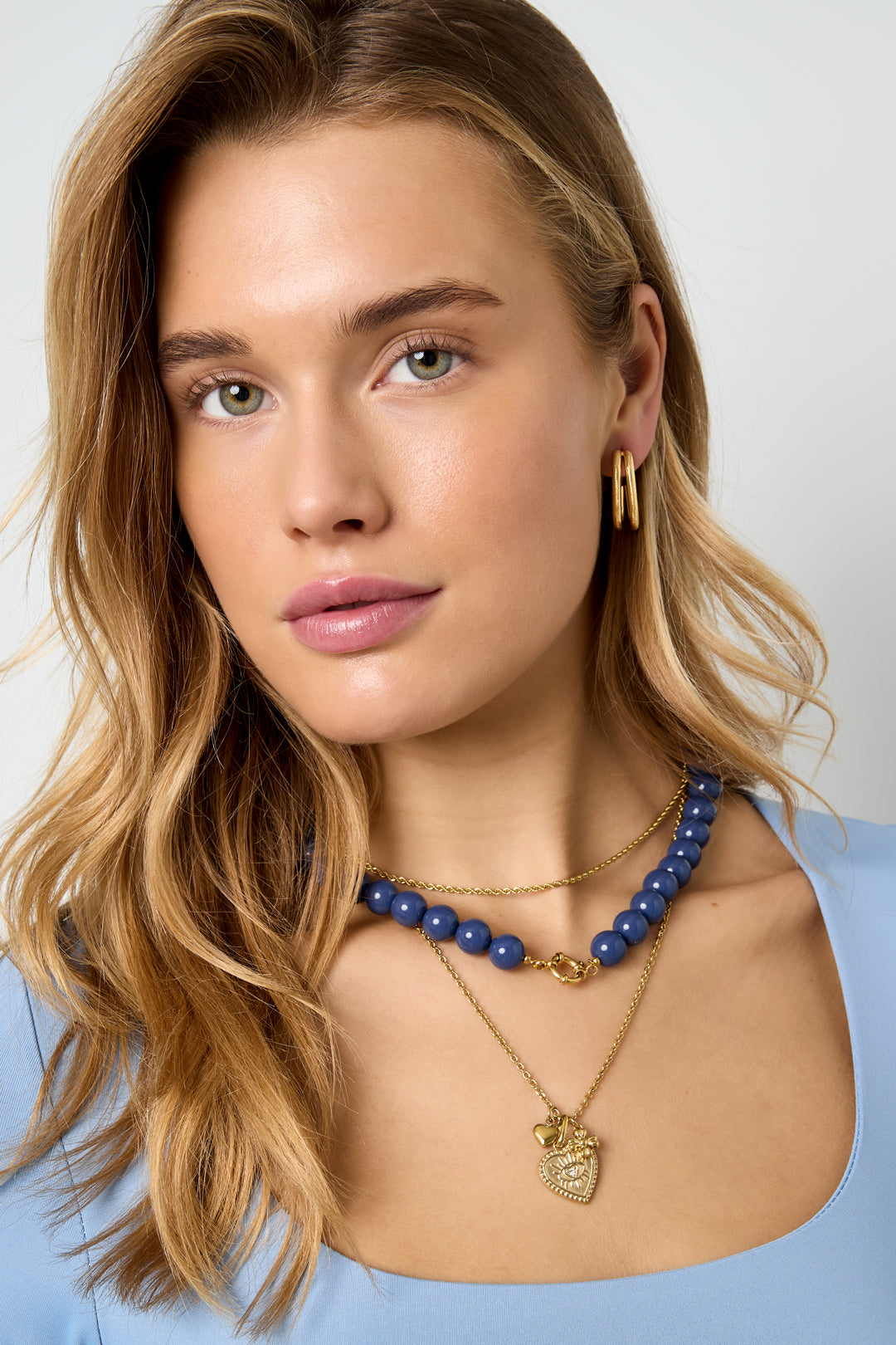 Kralenketting met sluiting aan de voorkant – 12 mm - donker blauw - gedragen om de hals van een model vooraanzicht