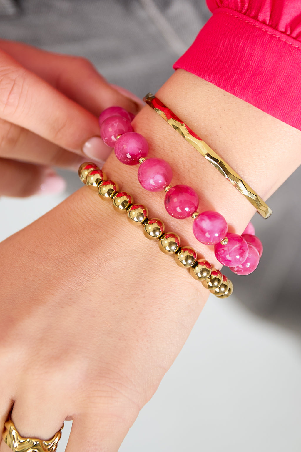 Armbandenset met ronde kralen - roze - gedragen om de arm van een model