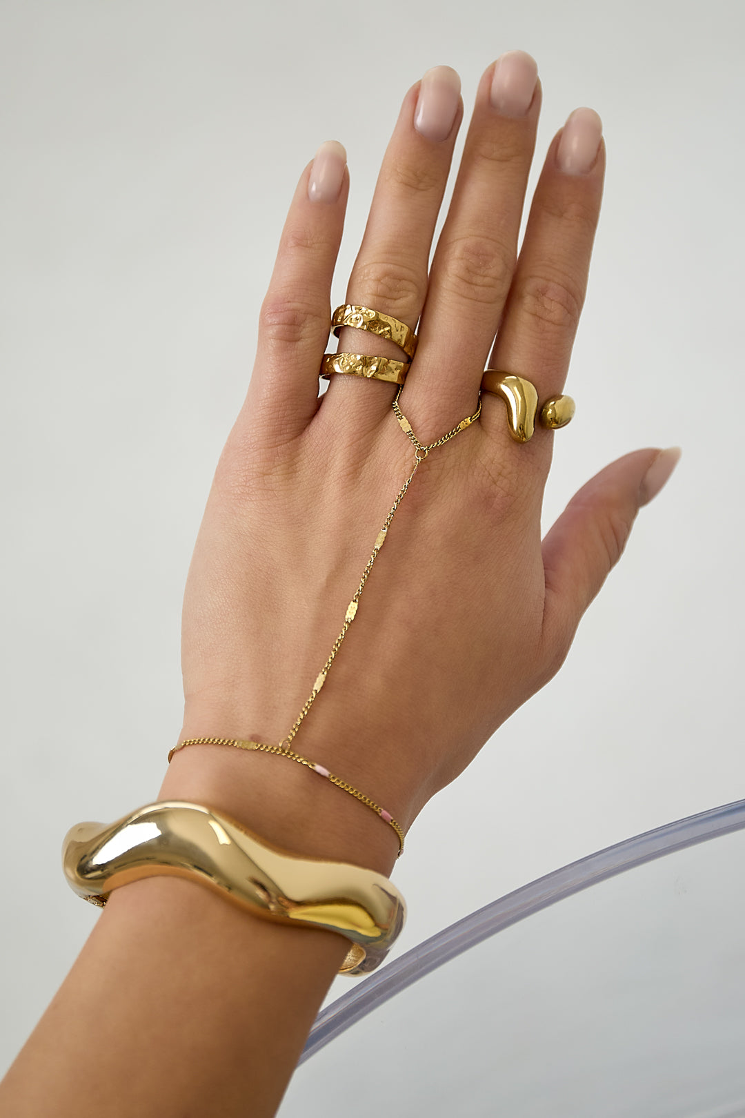 Handketting met gestreept patroon - goud - gedragen op de hand van een model