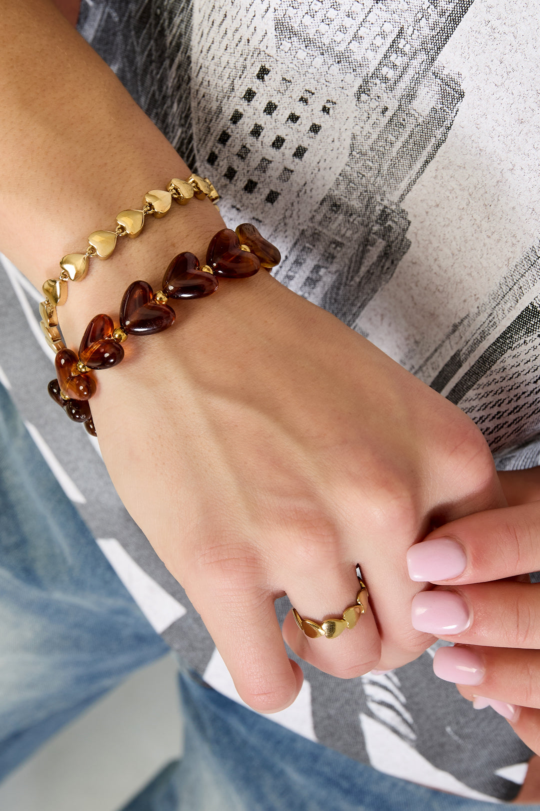 Elastische armband met hartkralen - bruin - gedragen om de arm van een model