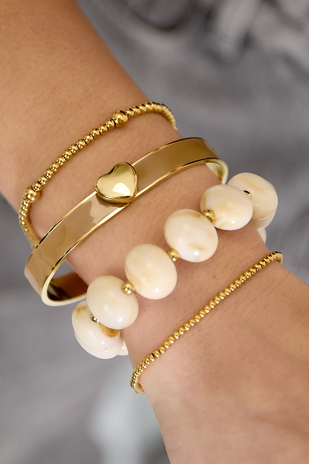 Armband  met hartdetail in verschillende kleuren – 0,9 cm - kaki - gedragen om de arm van een model