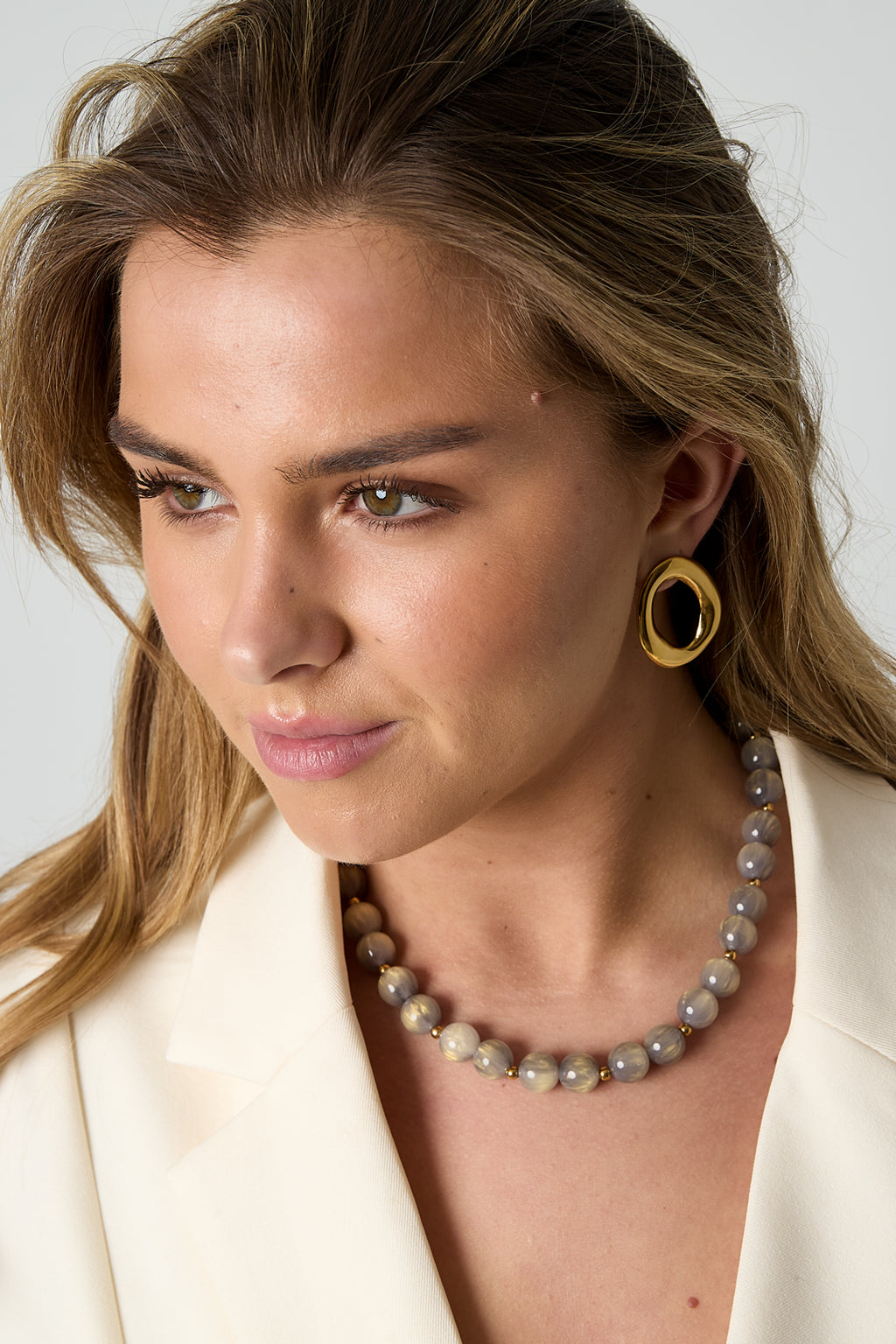 Kralenkettingen met gouden details – 12 mm - gedragen om de hals van een model