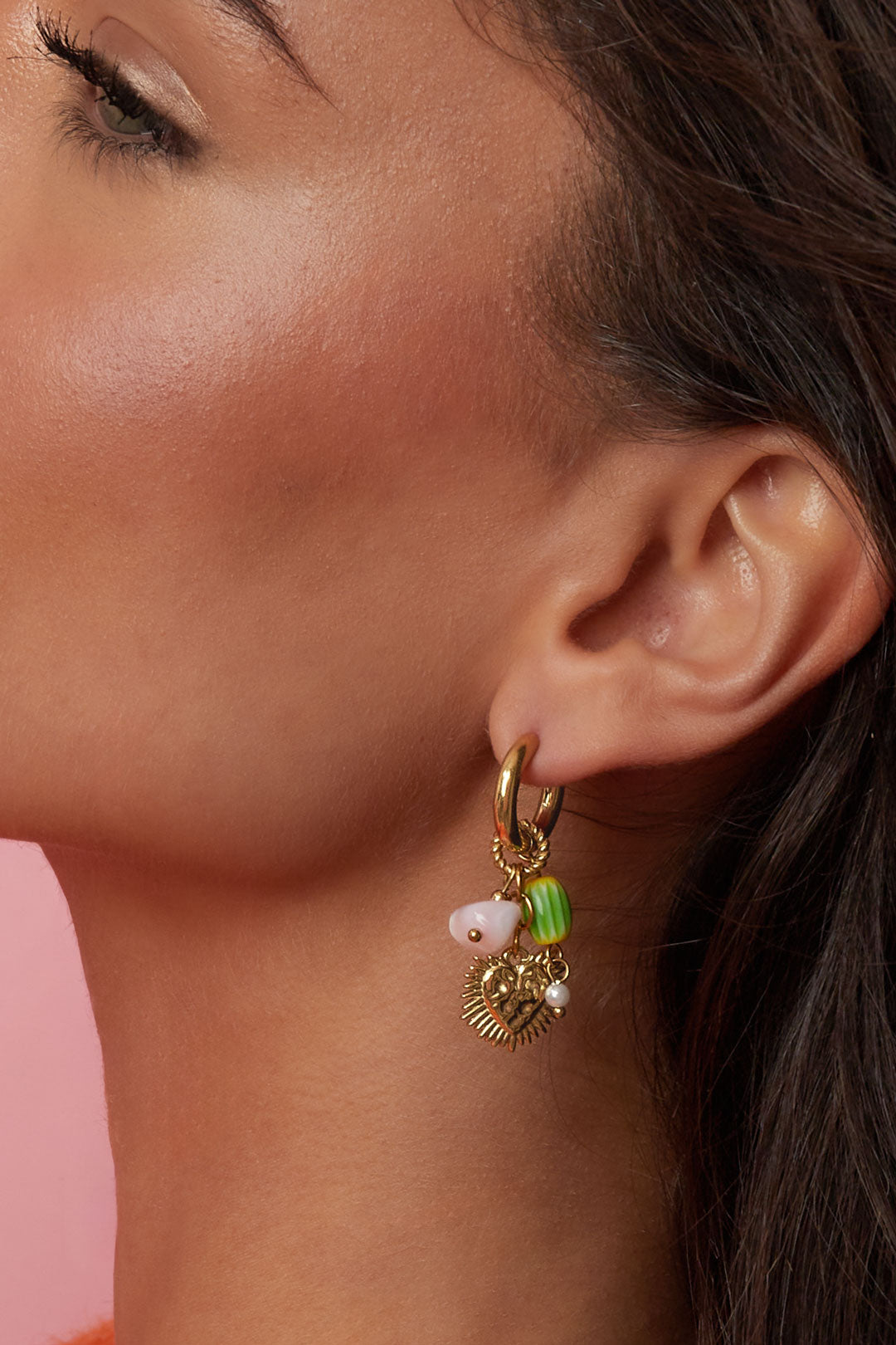 Oorringen met hart en kleurrijke kraalhangers - gedragen in het oor van een model