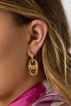 Oorbellen met knoopdetail - gedragen in het oor van een model ingezoomd