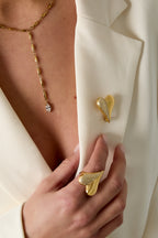 Broche in hartvorm met steentjes - gedragen op het jasje van een model