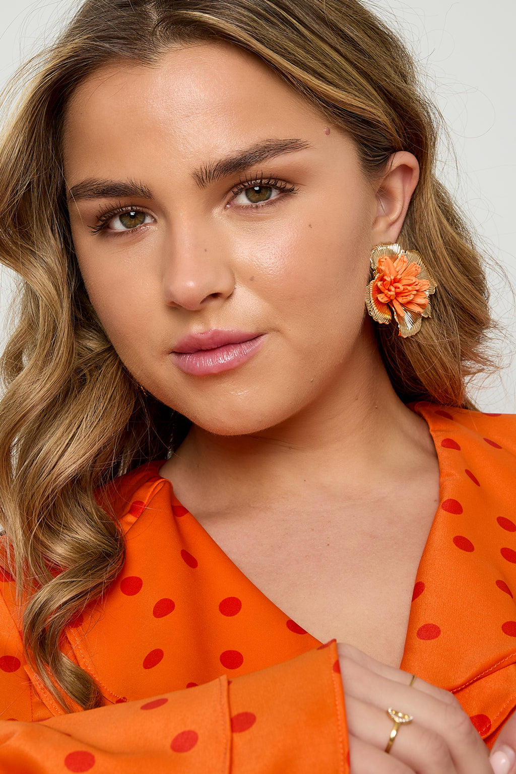 Oorbellen met 3D rafia bloem - oranje - gedragen in het oor van een model vooraanzicht