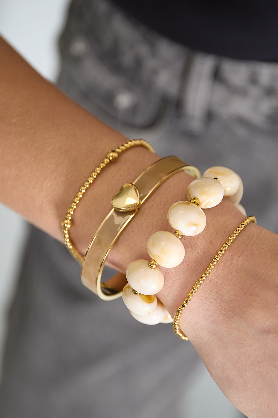 Elastieke kralenarmband met grote kralen - wit - gedragen om de arm van een model