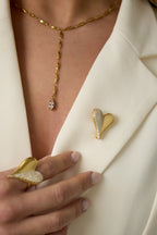 Broche in hartvorm met steentjes - gedragen op jasje van een model