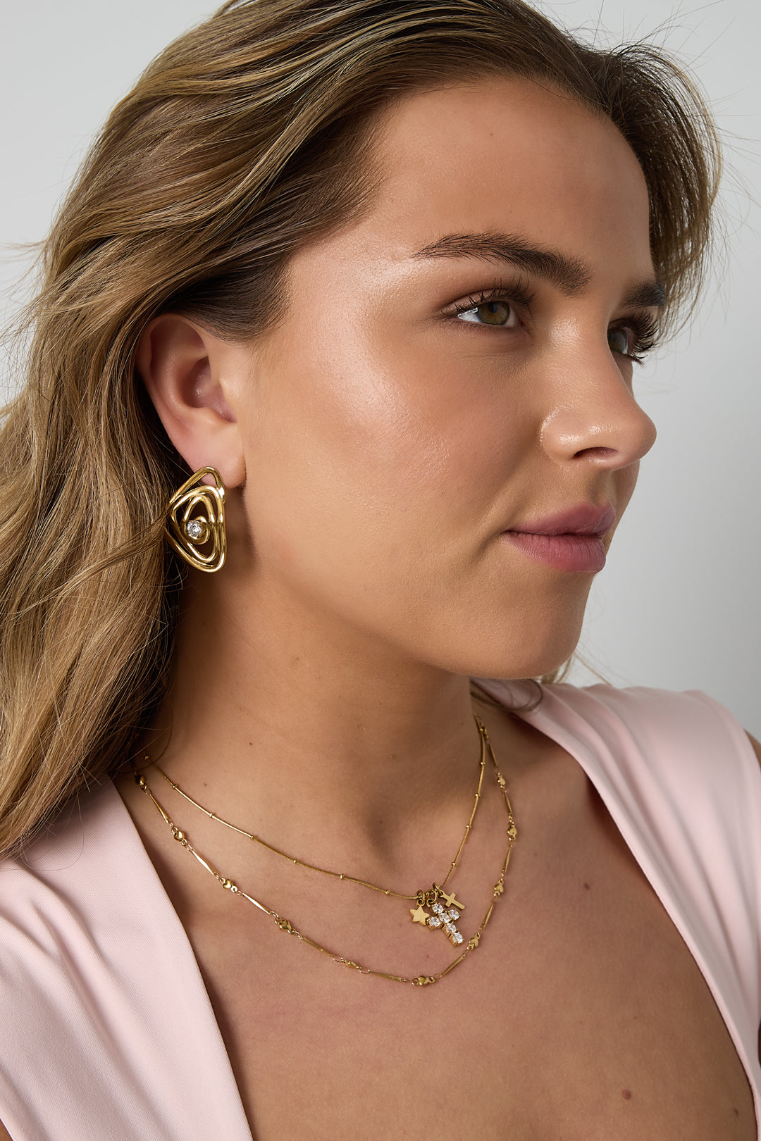 Ketting met kruis- en sterbedeltjes - goud - gedragen om de hals van een model vooraanzicht