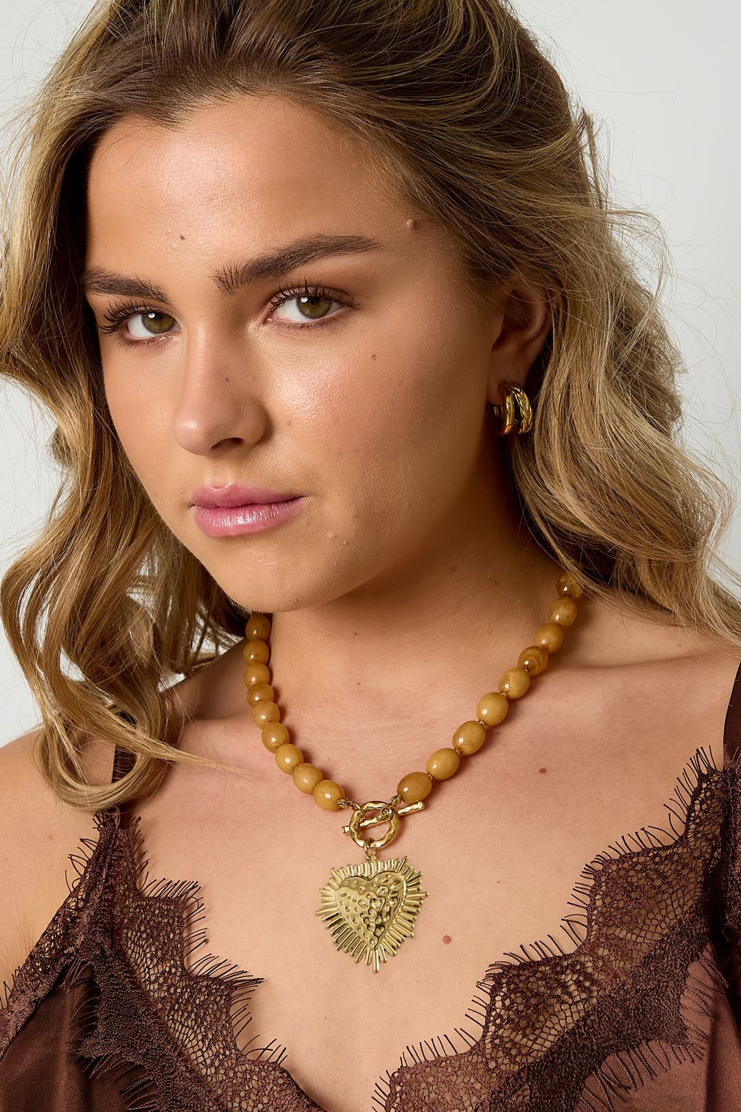 Kralenketting met frontsluitingcharm - kaki - gedragen om de hals van een model vooraanzicht