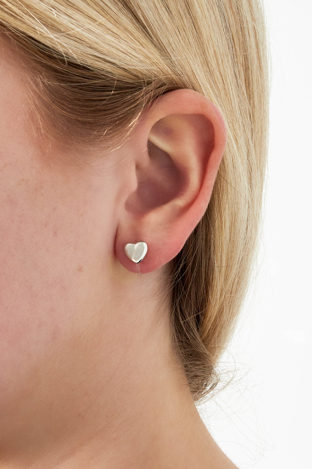 Mini hart clip-on oorbellen - gedragen in het oor van een model