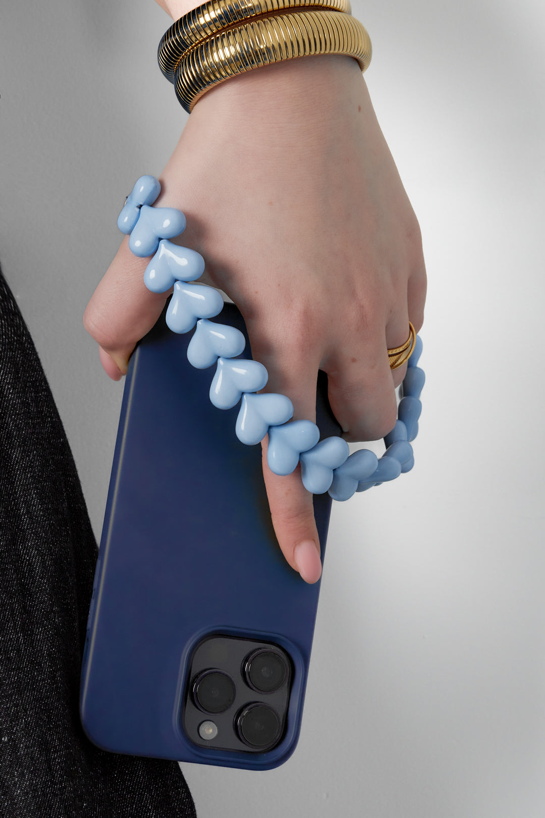 Telefoonketting met hartjes - licht blauwe - gedragen in de hand van een model
