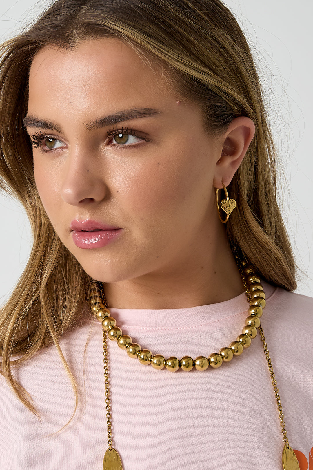 Oorringen met hartje - goud - gedragen in het oor van een model zijaanzicht