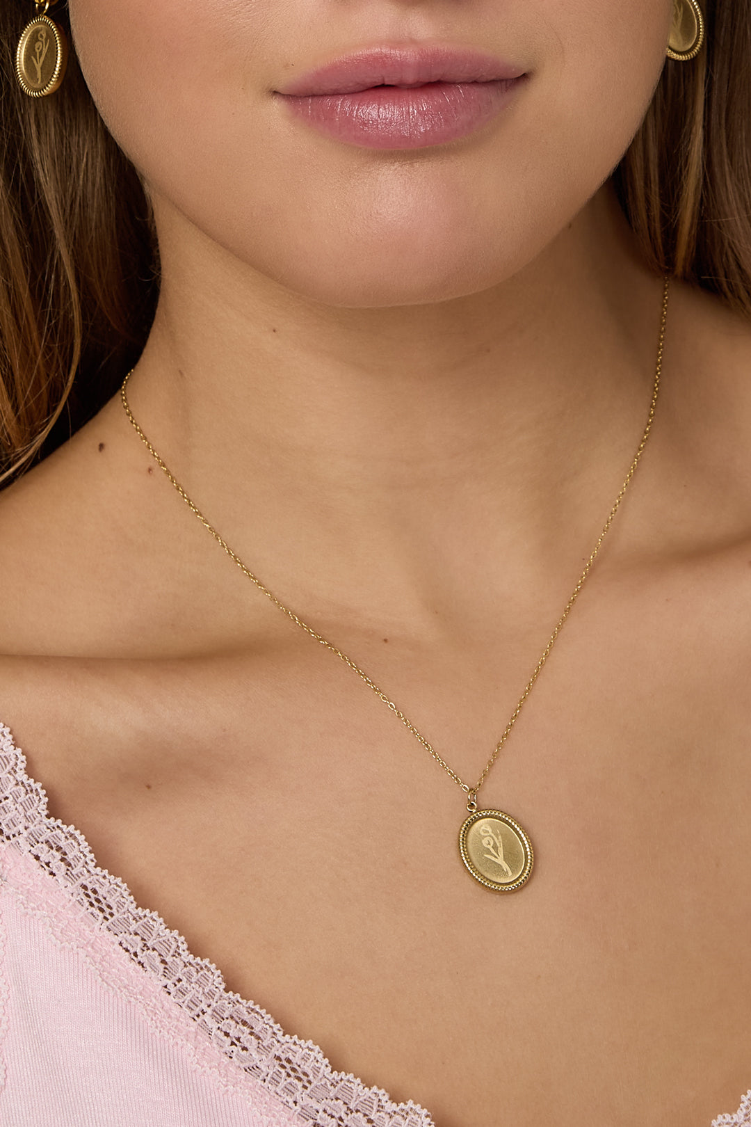 Tulpenbloem ketting van roestvrij staal - goud - gedragen om de hals van een model ingezoomd 