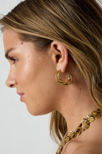 Dubbele dikke oorringen met gedraaide details - goud - gedragen in het oor van een model zijaanzicht