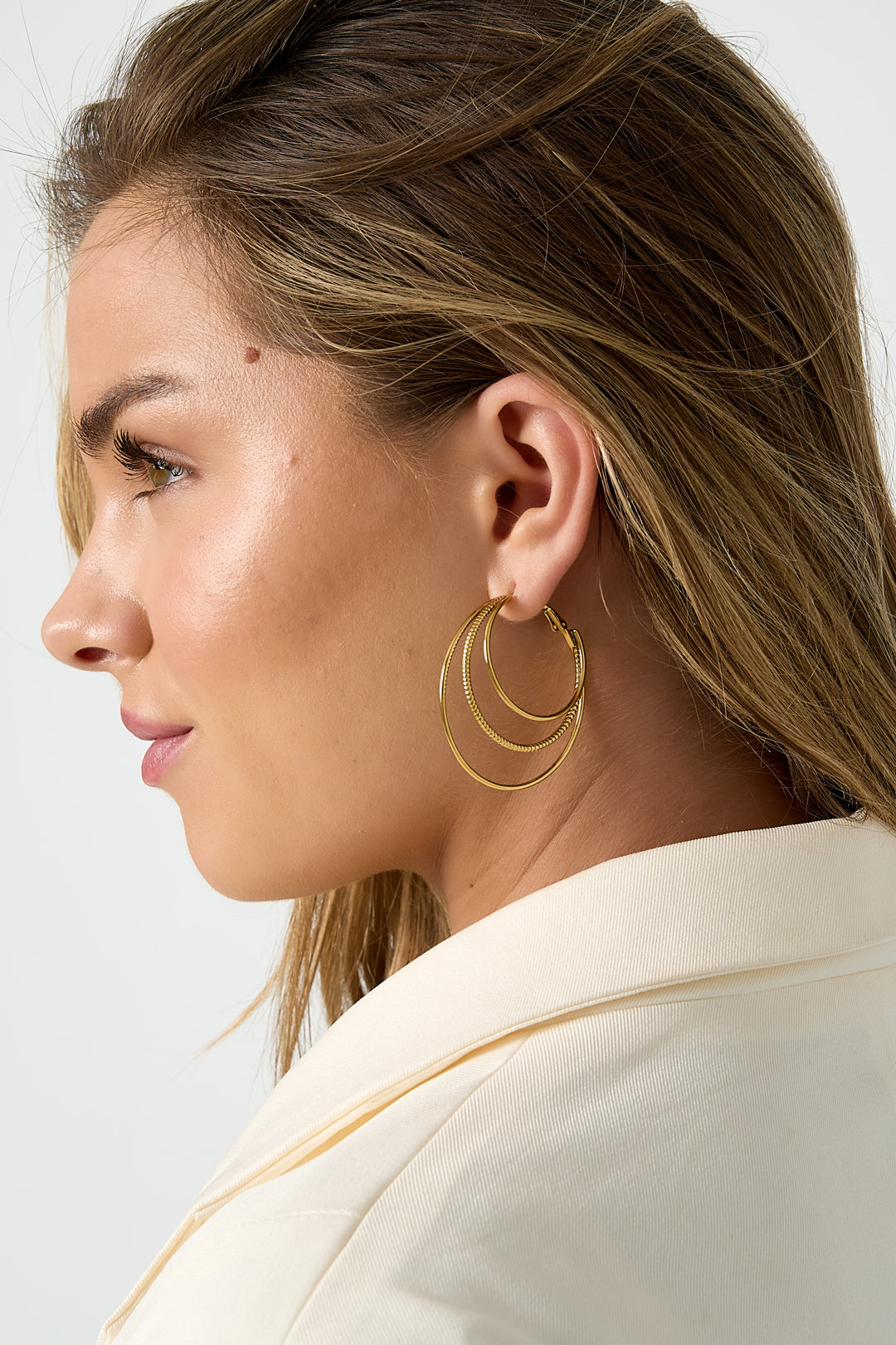 Gelaagde eenvoudige oorringen - goud - zijaanzicht van het gezicht van een model