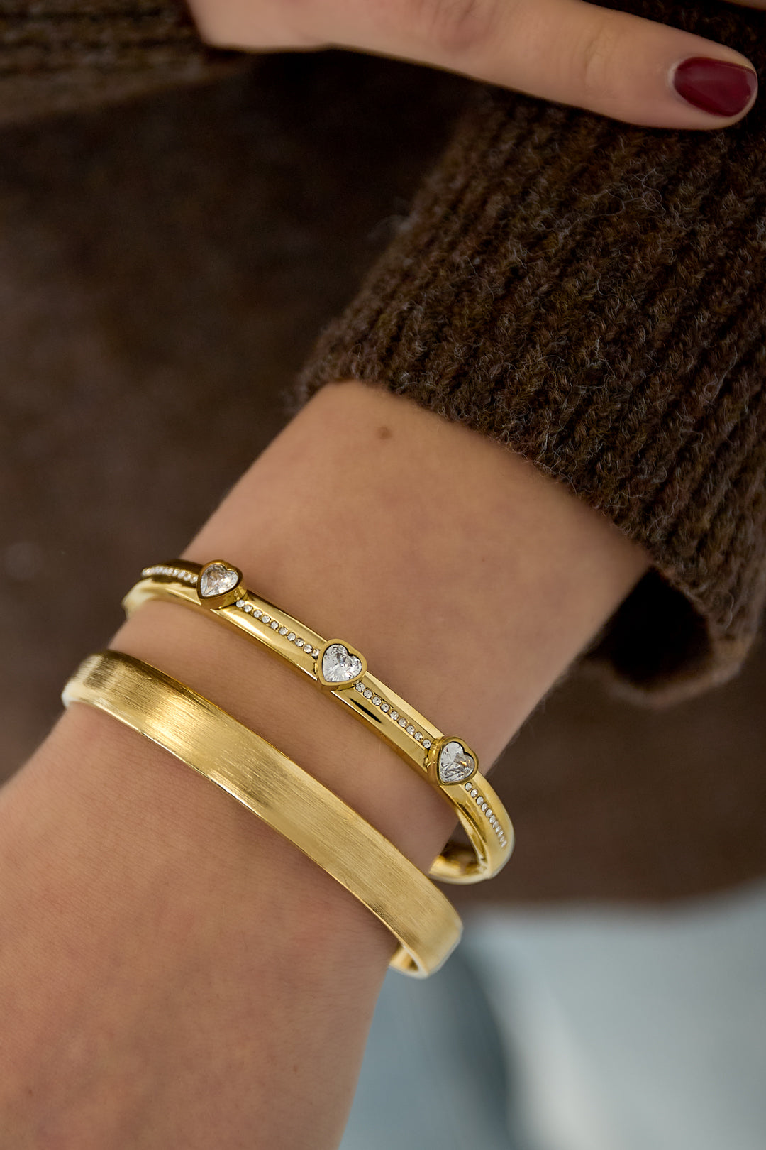 Armbanden van roestvrij staal met hart, goud - gedragen om de arm van een model