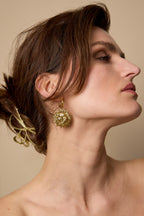 Oorbellen van roestvrij staal, zon, goud, gedragen in het oor van een model