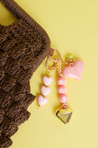 Tasbedels – Zoet acryl – licht roze - aan een tas gehangen met meer tashangers